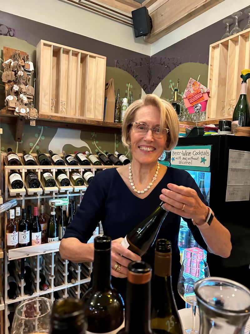 photo of Theresa Moran holding bottles of wine
